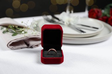 Nişan yüzüğü kutuda, çiçekler ve masa örtüsü üzerine masa örtüsü, yakın plan. Romantik yemek.