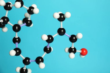 Açık mavi zemin üzerinde retinol molekülü (A vitamini), yakın plan. Kimyasal model