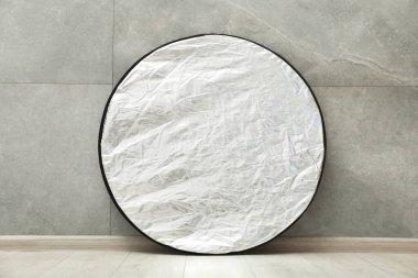 Kapalı alanda gri fayanslı bir ışık yansıtıcısı var. Fotoğraf stüdyosu ekipmanı