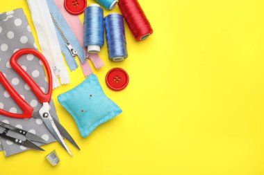 Sarı arka planda farklı dikiş malzemeleri var. Metin için boşluk