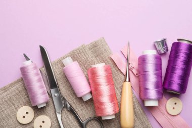 Leylak arka planında farklı dikiş malzemeleri var. Metin için boşluk