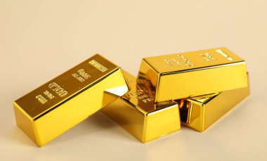 Bej arkaplanda parlak altın çubuklar, yakın plan