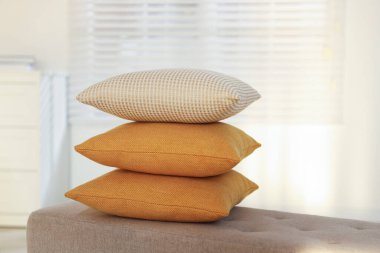 Odadaki kanepeye dekoratif yastıklar yığılmış.