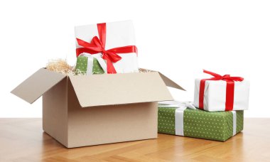 Beyaz arkaplana karşı ahşap masanın üzerinde hediye kutuları olan paket