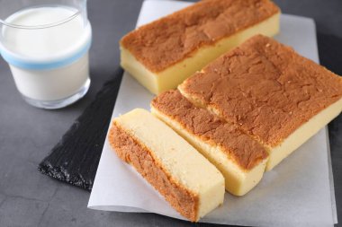 Tasty Japanese Castella sponge cake and milk on grey table, closeup