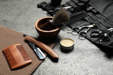 Gri desenli masada birçok farklı berber aleti var. Yakın plan.