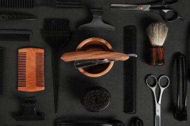 Siyah masanın üzerinde bir sürü farklı berber aleti vardı.