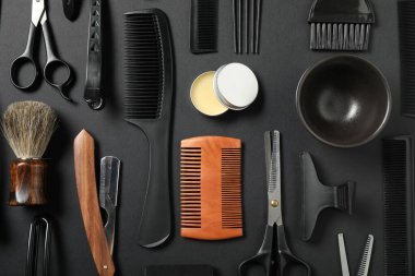Siyah masanın üzerinde bir sürü farklı berber aleti vardı.