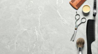 Many different barber's tools on light grey table, flat lay. Space for text