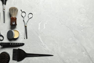 Many different barber's tools on light grey table, flat lay. Space for text