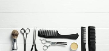 Beyaz ahşap masa üzerinde birçok farklı berber aletleri, düz yatıyordu. Metin için boşluk