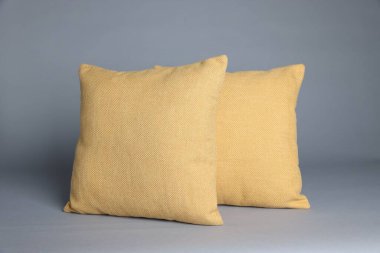 Gri arkaplanda iki yumuşak dekoratif yastık