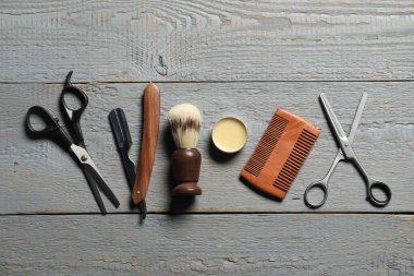 Açık gri ahşap masa üzerinde birçok farklı berber aletleri, düz yatıyordu