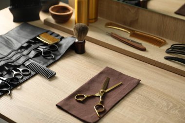 Berber dükkanında, açık ahşap masada birçok farklı berber aletleri var.