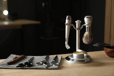 Berber dükkanında, açık ahşap masada birçok farklı berber aletleri var.