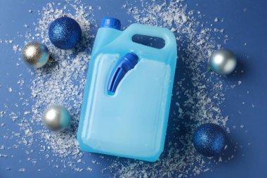 Plastik kapta antifriz, takılar ve mavi arka planda buz, düz bir zemin.