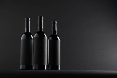 Siyah arkaplanda şarap şişeleri, metin için boşluk