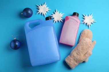 Açık mavi arka planda antifriz, eldivenler ve kış dekoru, düz yatıyordu.