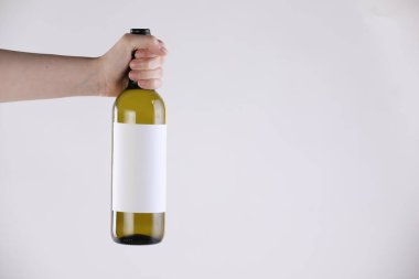 Beyaz arka planda şarap şişesi olan kadın, yakın plan. Metin için boşluk