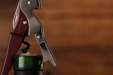 Arka planda tirbuşonlu bir şişe lüks şarap, yakın plan. Metin için boşluk