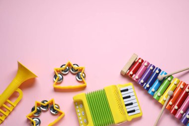 Düz kompozisyonda pembe arka planda farklı müzik aletleri vardı. Metin için boşluk