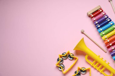 Düz kompozisyonda pembe arka planda farklı müzik aletleri vardı. Metin için boşluk