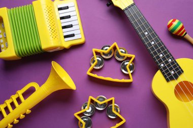 Mor zemin üzerinde farklı oyuncak müzik enstrümanları ile düz konum