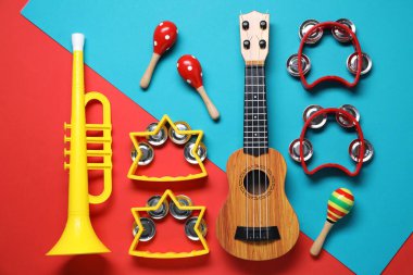 Renk arkaplan üzerinde farklı oyuncak müzik enstrümanları ile düz konum