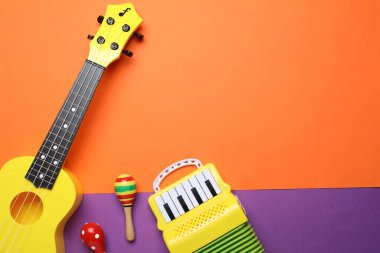 Renkli arka planda farklı oyuncak müzik aletleri, düz yatış. Metin için boşluk