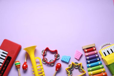 Menekşe arka planda farklı oyuncak müzik aletleri, düz yatış. Metin için boşluk