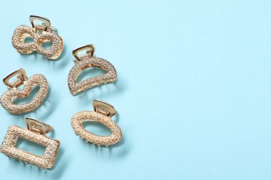 Açık mavi arka planda farklı saç tokaları, düz yatış. Metin için boşluk