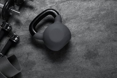 Kettlebell ve dambıllar gri arka planda, düz yatıyordu. Metin için boşluk