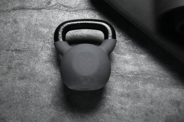 Gri arkaplanda kettlebell ve mat, üst görünüm