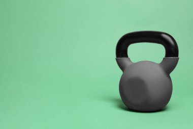 Yeşil arka planda ağır bir kettlebell. Metin için boşluk