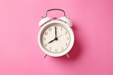 Pembe arka planda beyaz alarm saati, üst görünüm
