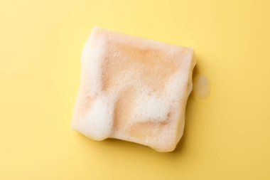 Sarı zemin üzerinde köpük olan sabun çubuğu, üst görünüm