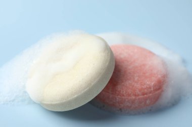 Açık mavi arka planda köpüklü sabun çubukları, yakın plan