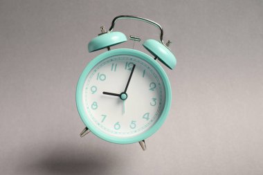 Açık gri arkaplanda turkuaz alarm saati