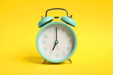Sarı arka planda bir turkuaz alarm saati