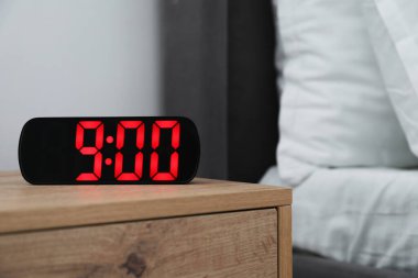 Dijital alarm saat 9: 00 'da kapalı bir masada.