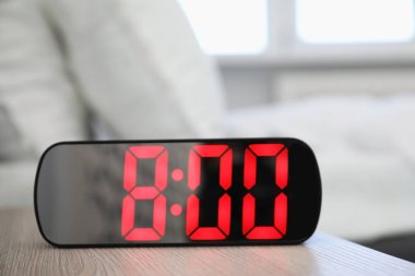 Dijital alarm saat 8 'de kapalı bir masada.