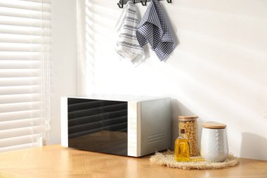 Kapalı mikrodalga fırın ve mutfak aletleri ahşap masa içinde.