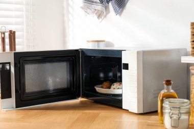 Mikrodalga fırını aç, pilav ve tavukla birlikte ahşap masa içinde.