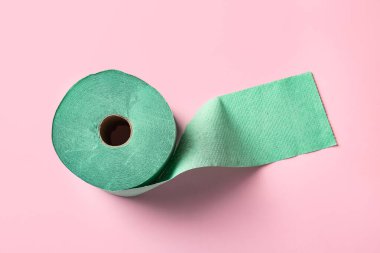 Açık pembe zemin üzerinde yeşil tuvalet kağıdı rulo, üst görünüm