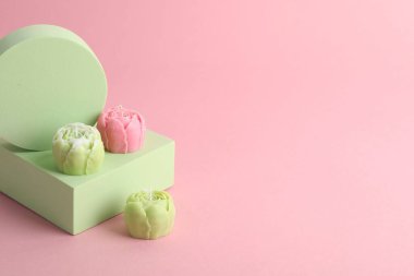 Pembe arka planda güzel çiçek şekilli mumlar. Metin için boşluk