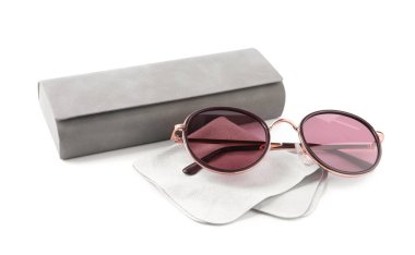 Bir gri çanta, güneş gözlüğü ve mercek bezi beyaza izole edilmiş.