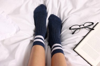 Yatakta mavi çorap giyen bir kadın.