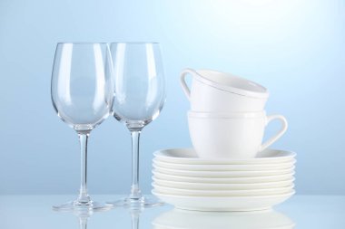 Different clean dishware on light blue background