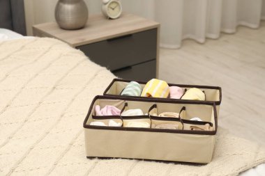 Yatağın içinde katlanmış giysileri olan organizatörler.