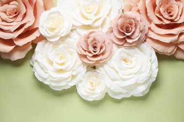 Açık yeşil zemin üzerinde güzel kağıt çiçekler, düz uzanmış